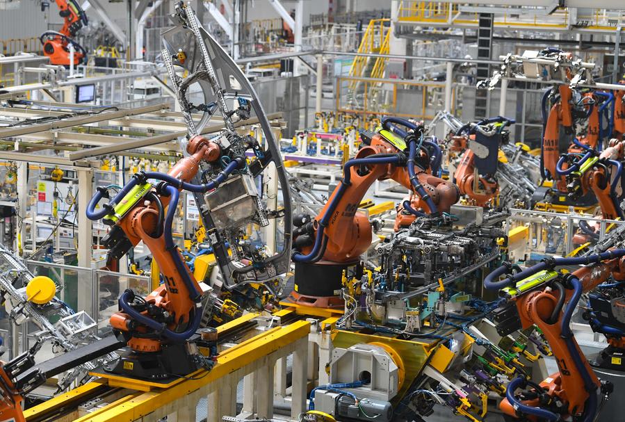 Automated vehicle production line with orange industrial robot arms